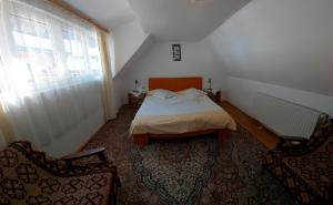 シビエルにあるPensiunea Andrei Sibielのベッドルーム1室(ベッド1台、椅子2脚付)