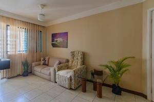 sala de estar con sofá y silla en Apt Lindíssimo com Piscina e Climatização, en Salvador