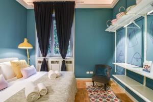 ミラノにあるSweet Inn - Cervaの青い壁のベッドルーム1室、ベッド1台(タオル付)