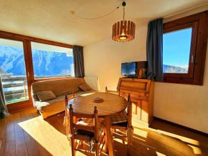 a living room with a table and a couch at Appartement Peisey-Nancroix-Plan Peisey, 2 pièces, 5 personnes - FR-1-757-90 in Peisey-Nancroix