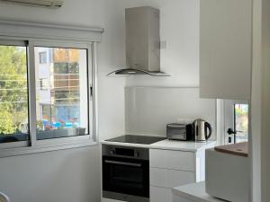 a white kitchen with a stove and a window at Anastasia 1 Bedroom Apartment in Limassol