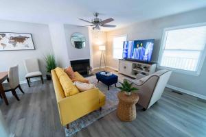 ein Wohnzimmer mit einem gelben Sofa und einem TV in der Unterkunft Prime location that feels like home away from home in Greensboro