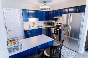 een keuken met blauwe kasten en een wit aanrecht bij Prime location that feels like home away from home in Greensboro