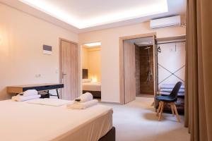 una habitación de hotel con 2 camas y una silla en Mini Suites Free shuttle from and to Athen's Airport, en Spáta