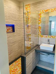 a bathroom with a sink and a shower at Residencial Sol Point Art in Ponta do Sol