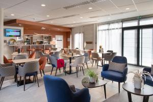 a restaurant with tables and chairs in a room at Domitys La Palangre in Le Tréport