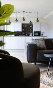 ein Wohnzimmer mit einem Sofa und einem Tisch in der Unterkunft Villa Wolde, Luxe villa (10p.) met Hottub in Zeewolde