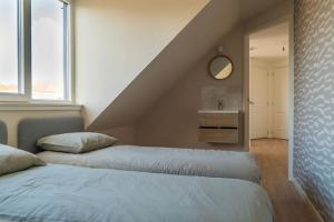 1 Schlafzimmer mit 2 Betten und einem Waschbecken in der Unterkunft Villa Wolde, Luxe villa (10p.) met Hottub in Zeewolde