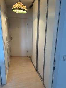 a hallway with glass doors and a light fixture at Ferienwohnung CASA GELI in Glücksburg