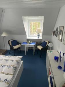 Schlafzimmer mit einem Bett, einem Tisch und einem Fenster in der Unterkunft Seeblick in Westensee