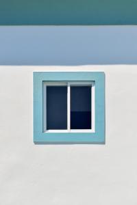 a window on the side of a building at A Muralha in Tavira