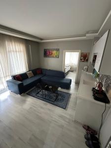 een woonkamer met een blauwe bank en een tafel bij Zirve Suit Residance in Talas