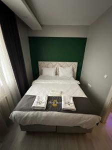 a bedroom with a bed with a green headboard at Zirve Suit Residance in Talas