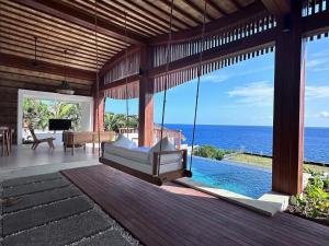 - une balançoire dans une maison avec vue sur l'océan dans l'établissement The Angsa villas, à Amed