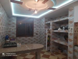 cocina con mesa y ventilador de techo en Maison Lahoucine en Sidi Ifni