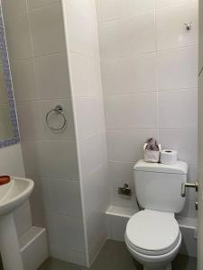 a white bathroom with a toilet and a sink at Departamento moderno, vista al mar y estacionamiento incluido in Antofagasta +7 photos