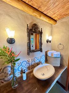 a bathroom with a sink and a mirror on the wall at Quinta dos Laranjais Chalés in Viçosa do Ceará