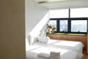 a bedroom with a white bed and a large window at Gangnam Coex in Seoul