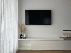 a living room with a tv on a white wall at City Luxe Apartment in Čakovec