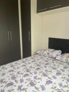 uma cama com um edredão floral e 2 almofadas em Apartamento no Morumbi em São Paulo