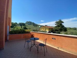 een patio met 2 stoelen en een tafel op een balkon bij Locanda LaRotonda in Villa Verucchio
