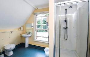 uma casa de banho com um chuveiro, um WC e um lavatório. em Selwyn College, Cambridge em Cambridge