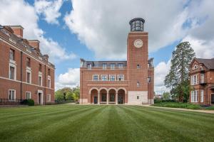 a large brick building with a clock tower on it at Selwyn College, Cambridge in Cambridge
