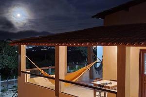 a porch with a hammock outside of a house at Solar Serra Negra Bezerros - PE in Bezerros