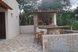 a patio with an outdoor kitchen with a table and stools at Solar Serra Negra Bezerros - PE in Bezerros +6 photos