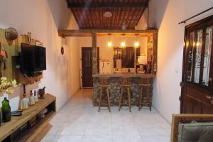 a room with a bar with stools and a television at Solar Serra Negra Bezerros - PE in Bezerros