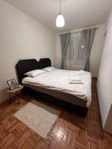 a bedroom with a large bed with white sheets at Una Apartment in Sarajevo