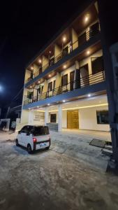 a car parked in front of a building at night at Batik Inn Semarang in Semarang