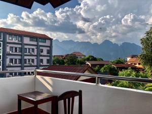 una silla en el balcón con vistas a las montañas en Easy go backpacker hostel, en Vang Vieng