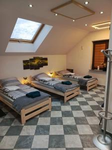 three beds in a room with a checkered floor at Apartament Pod Bukami in Łaziska Górne