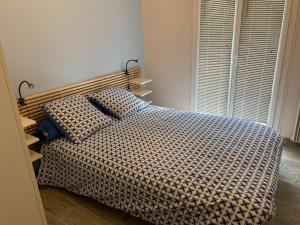 een slaapkamer met een bed met een geruite deken bij Le jasmin du Riou in Cannes