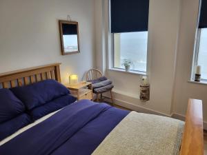 a bedroom with a bed and a chair and windows at Imperial House "Serviced Apartments" in Margate