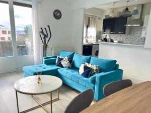 sala de estar con sofá azul y mesa en Proche Paris - Parking - 2 Chambres - 5 personnes, en Fresnes