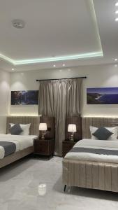 a bedroom with two beds and two lamps at شقق ثمانين بارك 2 in Khamis Mushayt