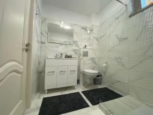 y baño blanco con ducha y aseo. en Tei Residence, en Piatra Neamţ