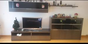 een entertainmentcentrum met een flatscreen-tv op een tafel bij Habitacion con Piscina y Sauna in Sant Cugat del Vallès