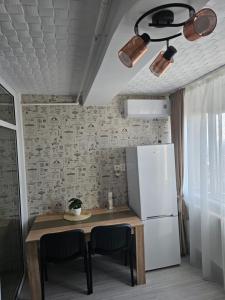 Il comprend une cuisine équipée d'une table et d'un réfrigérateur. dans l'établissement Garsoniera Dary strada Mihai Bravu bloc G1 Vis a Vis de ROYAL PALACE, à Turnu Măgurele