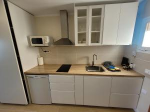 a small kitchen with a sink and a microwave at Cosy ocean view studio 2 in San Marcos +12 photos