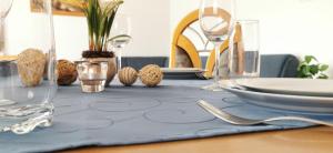 stół z niebieską tkaniną stołową z płytami i okularami w obiekcie Appartements Mary inklusive Tauern-Spa Kaprun w Kaprunie