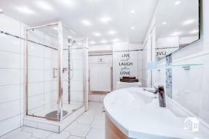 een witte badkamer met een douche en een wastafel bij Sonnenhaus in Frauenstein