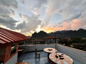 2 mesas en un balcón con vistas a las montañas en Easy go backpacker hostel, en Vang Vieng