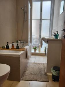 a bathroom with a tub and a shower and a sink at Imperial House "Serviced Apartments" in Margate +35 photos
