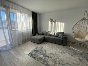 a living room with a couch and a large window at Tei Residence in Piatra Neamţ