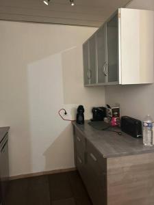a kitchen with a counter and cabinets and a counter top at Superbe appartement avec parking gratuit in Vaulx-en-Velin