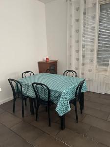 mesa de comedor con sillas y mantel azul y blanco en Superbe appartement avec parking gratuit, en Vaulx-en-Velin