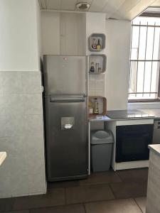a kitchen with a stainless steel refrigerator and a sink at Superbe appartement avec parking gratuit in Vaulx-en-Velin